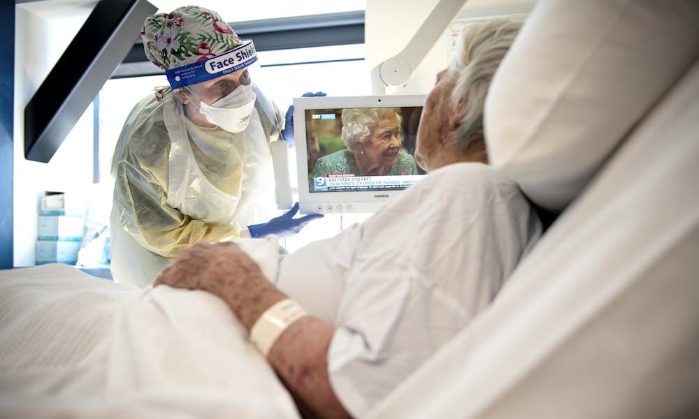 Nurse with a patient in bed on a ward