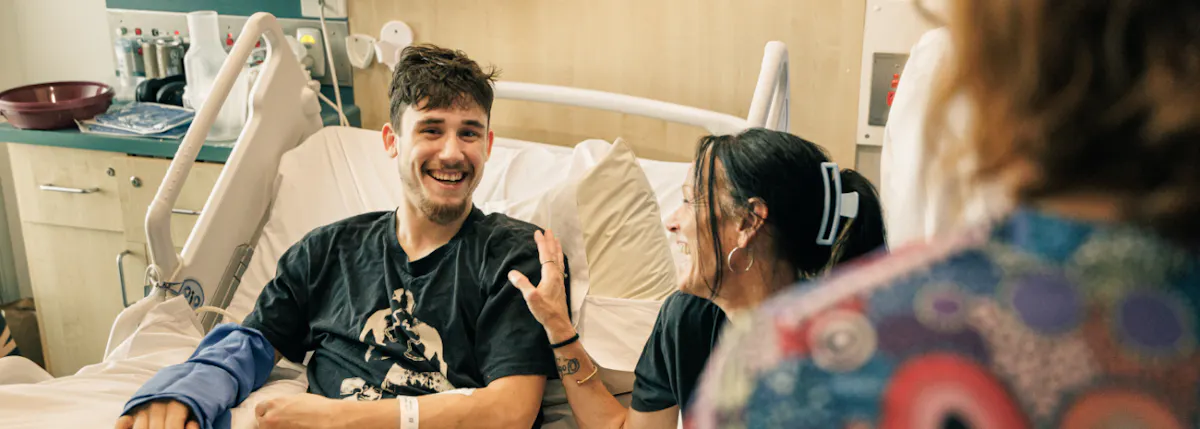 smiling-patient-with-arm-cast-in-hospital-bed.jpg