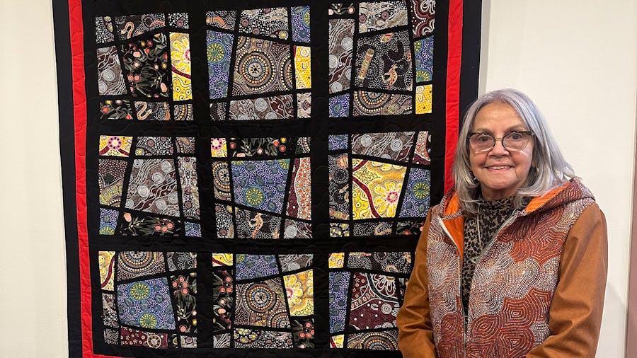 aunty-marlene-scerri-in-front-of-quilt-hung-on-display.jpg