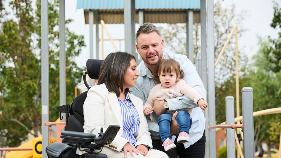 Brianna seated at playground with her family