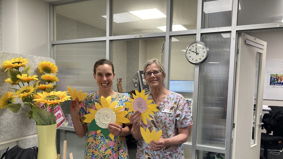 Disability Liaison Officers holding paper sunflowers