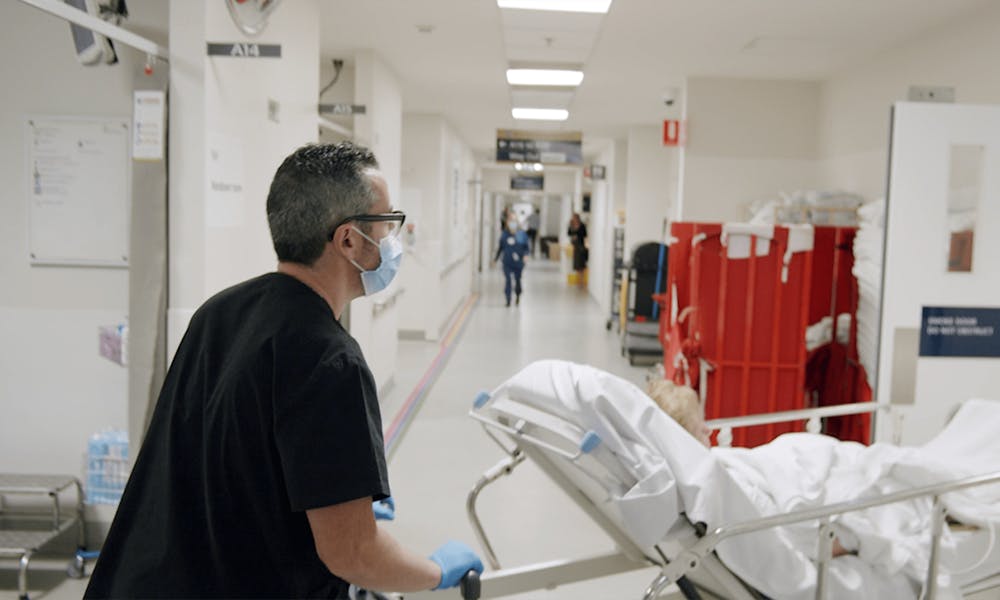 Clinical assistant moving patient from Emergency
