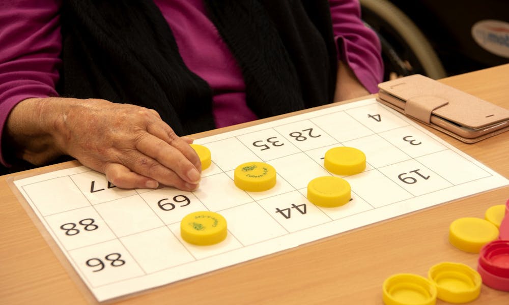 Close up view of residents hands playing numbers game at Cyril Jewell House