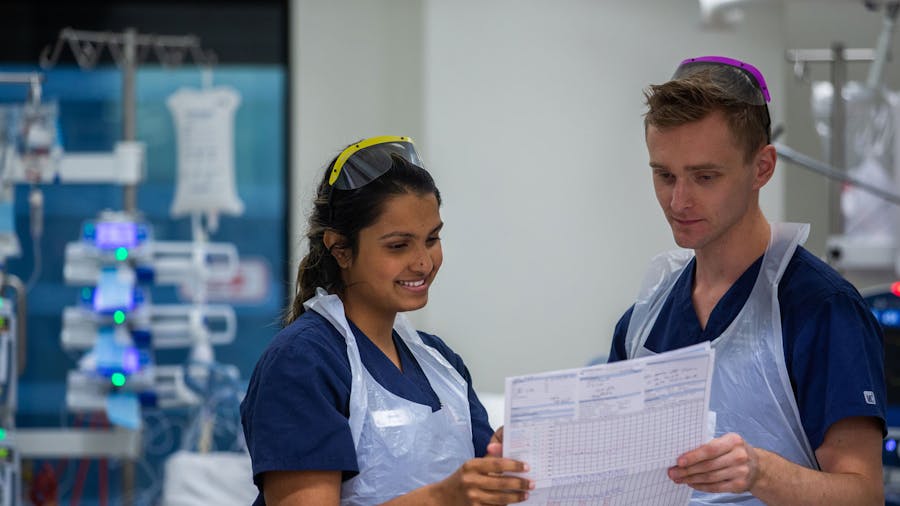 Two ICU nurses looking at chart