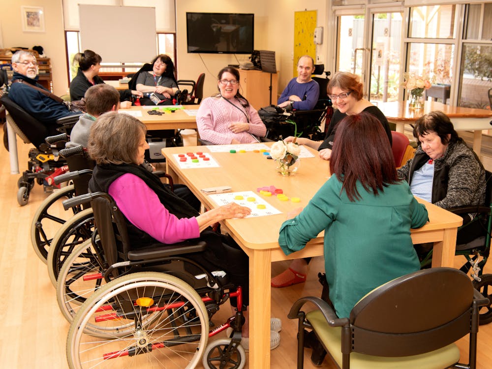Residents playing numbers game around a table at Cyril Jewell House