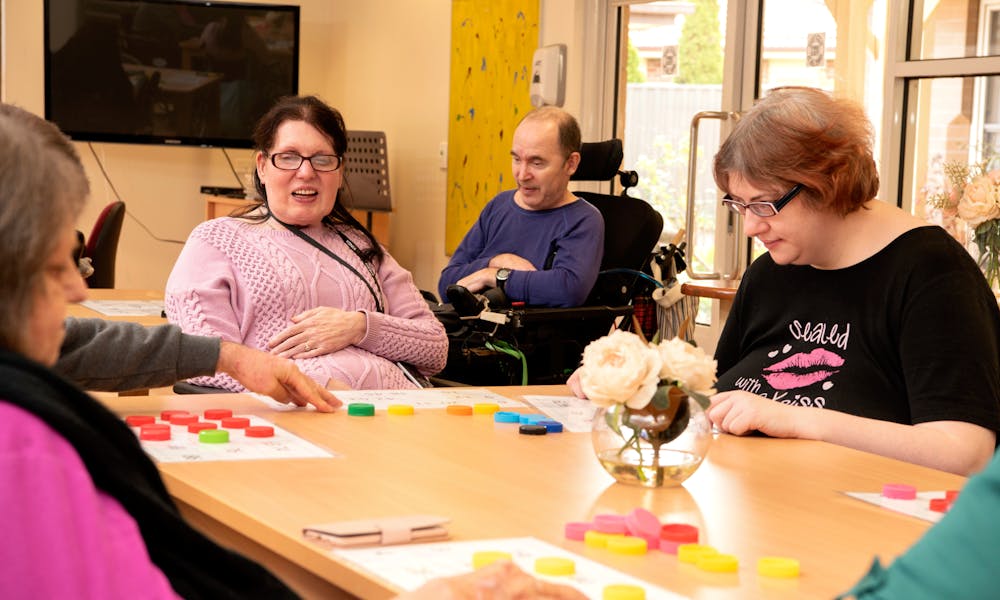 Residents playing tabletop game at Cyril Jewell House