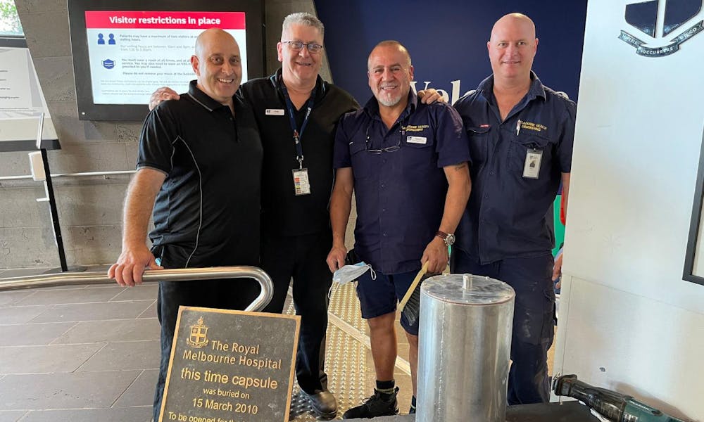 Team of engineers with the time capsule and plaque in 2023