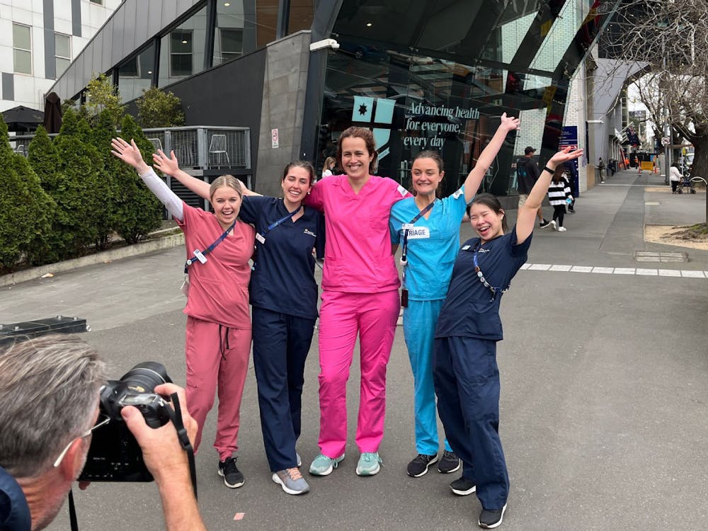 Staff in scrubs being photographed outside the RMH Parkville main entrance