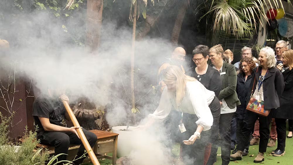 Staff participating in smoking ceremony for NAIDOC week 2023