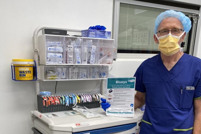 Staff member holding the Alternatives to Blueys poster