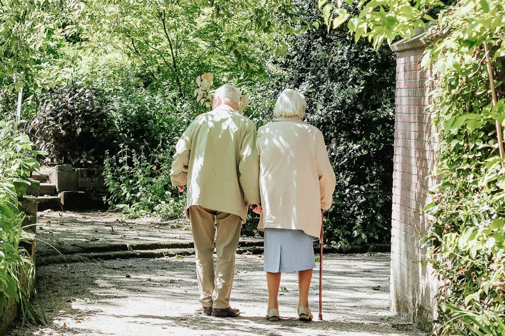 Two older people walking outside